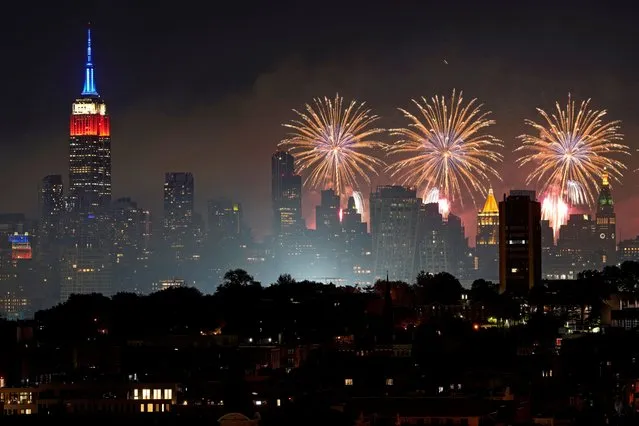 Fireworks explode near the Empire State Building and over the New York City skyline and Hoboken, N.J., during Macy's 46th annual Fourth of July fireworks display on Monday, July 4, 2022, as seen from Jersey City, N.J. (Photo by Charles Sykes/AP Photo) 