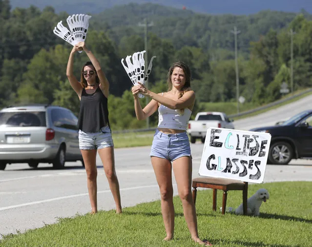 Ashley Ann Sander, left, and Alexandra Dowling hawk solar eclipse glasses for $10 a pair on the side of the road to tourists approaching Clayton, Ga., Sunday, August 20, 2017. Clayton is in the path of totality in North Georgia. (Photo by Curtis Compton/Atlanta Journal-Constitution via AP Photo)