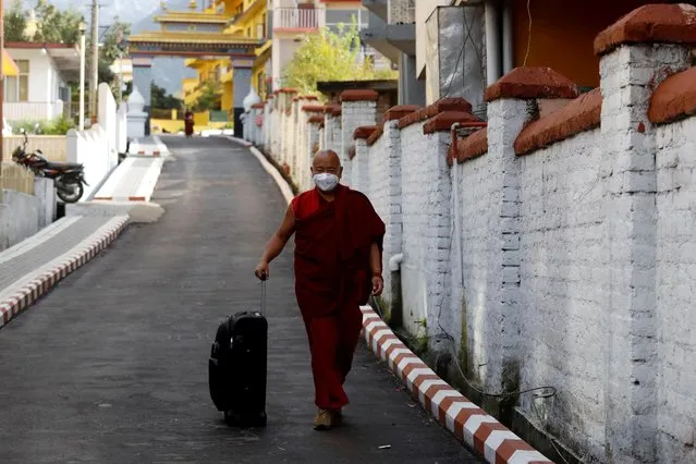 A Tibetan monk wearing mask walks out of the Gyuto Tantric Monastery which has been closed for a month amid coronavirus fears, in Dharamsala, India, March 12, 2020. (Photo by Anushree Fadnavis/Reuters)