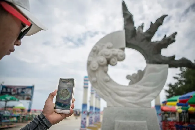 A South Korean youth checks the landmark visible on Pokemon Go application on July 15, 2016 in Sokcho, South Korea. (Photo by Jean Chung/Getty Images)
