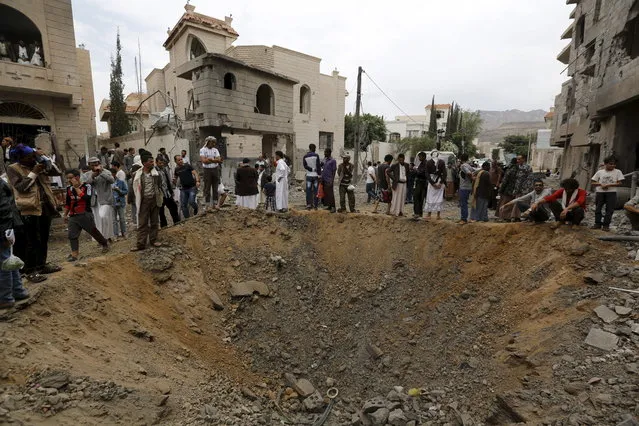 People stand around a crater at the site of a Saudi-led air strike in Yemen's capital Sanaa August 30, 2015. (Photo by Khaled Abdullah/Reuters)