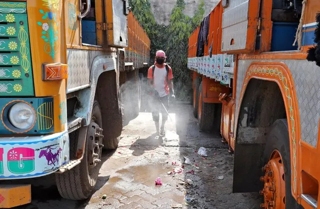A municipal works as he disinfects parked supply truck at a yard during a 21-day nationwide lockdown to limit the spreading of coronavirus disease (COVID-19), on the outskirts of Kolkata, India, March 27, 2020. (Photo by Rupak De Chowdhuri/Reuters)