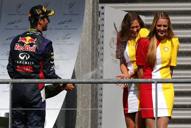 Red Bull Formula One driver Daniel Ricciardo of Australia (L) sprays champagne on hostesses while celebrating his victory in the Belgian Grand Prix in Spa-Francorchamps August 24, 2014. (Photo by Yves Herman/Reuters)