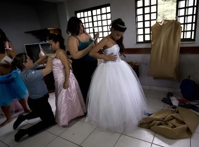 Teenage girls get dressed for their debutante ball, which relied on volunteers who coiffed and made up the girls and a formal wear shop that loaned the dresses. (Photo by Silvia Izquierdo/AP Photo via The Palm Beach Post)