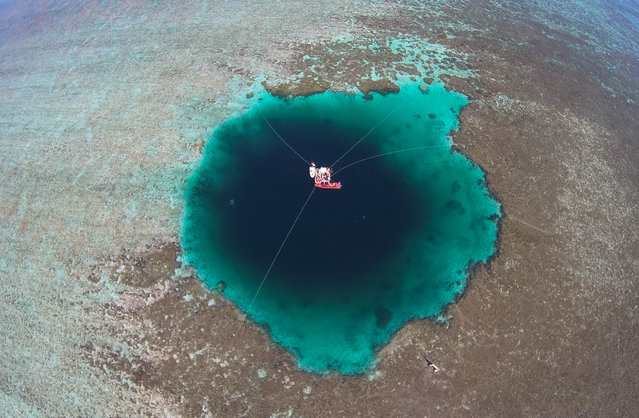 Aerial view of the experts and staff exploring the Sansha Yongle Blue Hole on July 24, 2016 in Xisha Islands, Sansha City, Hainan Province of China. Sansha municipal government has named the world's deepest ocean blue hole as “Sansha Yongle Blue Hole” which is located around the Yongle atoll of the Xisha Islands. The hole has a vertical depth of 300.89 meters, a diameter of 130 meters on the surface, and its bottom's diameter is 36 meters. No connection between the hole and the outside sea has been found so far and the water inside the hole has no obvious flow. (Photo by Luo Yunfei/CNSPHOTO/VCG)