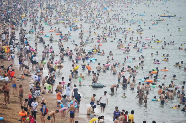 People cool off on a beach in Qingdao, Shandong province, July 30, 2016. Picture taken July 30, 2016. (Photo by Reuters/Stringer)