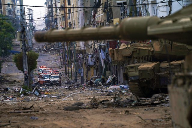 Ambulances are seen on a road near an Israeli forces tank during an Israeli army ground operation in the Gaza Strip, Wednesday, November 22, 2023. (Photo by Victor R. Caivano/AP Photo)