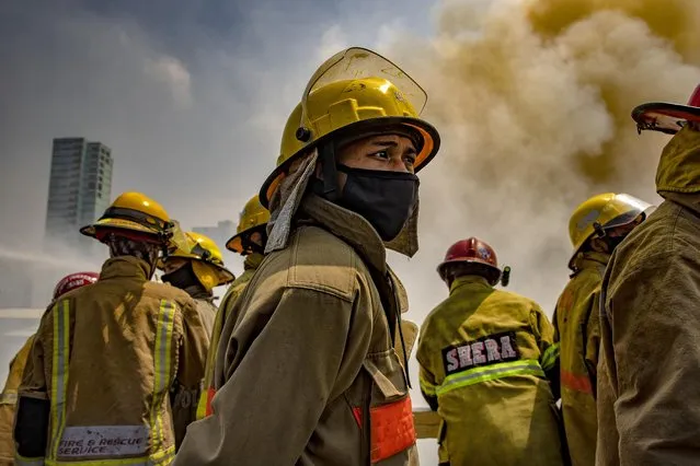 A firefighter is seen wearing a facemask as a fire engulfs houses of a slum community on April 15, 2020 in Manila, Philippines. According to authorities, more than a hundred residents were rendered homeless after a fire razed the slum community, amid a government lockdown which has made the country's homeless vulnerable and in need of aid. Close to 70 percent of the homeless population are in Metro Manila and survive by begging, or collecting and reselling plastic and metal scraps. The Philippines' main island Luzon, which includes the capital Manila, remains on lockdown as authorities continue to struggle with the growing number of coronavirus, Covid-19 cases. Land, sea, and air travel has been suspended, while government work, schools, businesses, and public transportation have been ordered shut in a bid to keep some 55 million people at home. The Philippines' Department of Health has so far confirmed 5,223 cases of the coronavirus in the country, with at least 335 recorded fatalities. (Photo by Ezra Acayan/Getty Images)