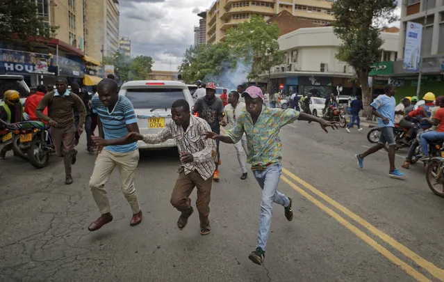 Supporters of opposition leader Raila Odinga flee from police firing tear gas as they attempt to demonstrate in downtown Nairobi, Kenya Tuesday, October 24, 2017. Kenyan police have fired tear gas and warning shots to disperse small groups of opposition protesters ahead of a presidential election on Thursday that opposition leader Raila Odinga plans to boycott. (Photo by Ben Curtis/AP Photo)