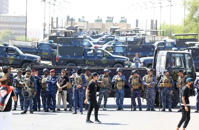 Security forces block a road during protests in Tahrir Square as anti-government protesters try to enter the Green Zone of Baghdad, Iraq, 28 September 2022. Hundreds of Iraqis clashed with security forces as the Iraqi parliament was due to convene for the first time since deadly unrest in August and a sit-in protest by supporters of Shiite cleric and Sadrist movement leader Muqtada al-Sadr. (Photo by Ahmed Jalil/EPA/EFE)