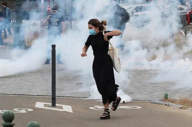 A demonstrator flees from tear gas during a protest, organised by Black Lives Matter Belgium, against racial inequality in the aftermath of the death in Minneapolis police custody of George Floyd, in central Brussels, Belgium on June 7, 2020. (Photo by Yves Herman/Reuters)