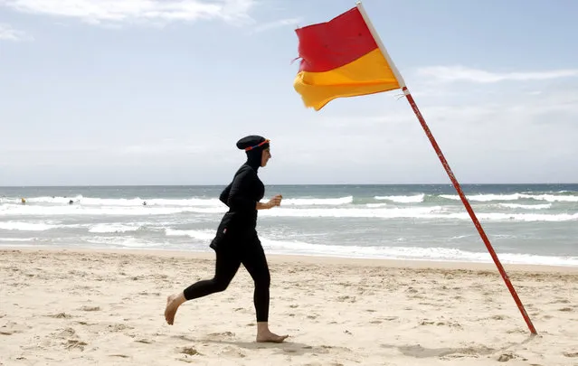 Twenty-year-old trainee volunteer surf life saver Mecca Laalaa runs along North Cronulla Beach in Sydney during her Bronze medallion competency test January 13, 2007. Specifically designed for Muslim women, Laalaa's body-covering swimming costume has been named the “burkini” by its Sydney based designer Aheda Zanetti. (Photo by Tim Wimborne/Reuters)