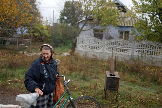 A local resident stands next to a wood stove delivered by volunteers in a village near a frontline, amid Russia's attack on Ukraine, in Mykolaiv region, Ukraine on October 25, 2022. (Photo by Valentyn Ogirenko/Reuters)
