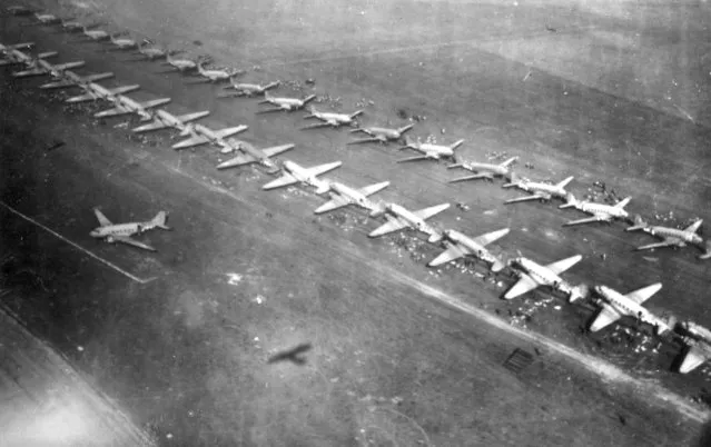Long twin lines of C-47 airplanes are seen waiting to take off for Holland at an unknown British airfield on September 17, 1944. The planes carry paratroopers of the 1st Allied Airborne Army and are loaded with war supplies. (Photo by AP Photo)