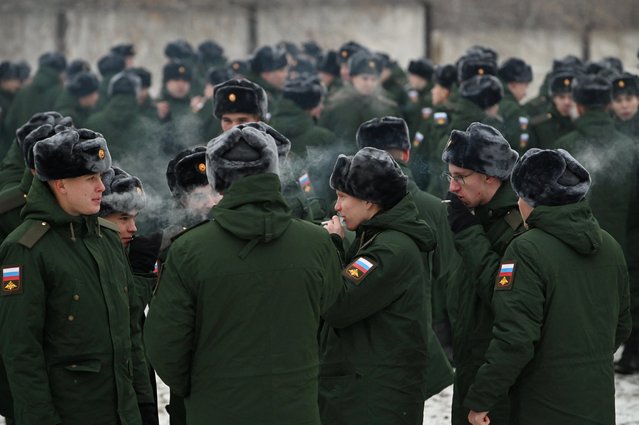 Russian conscripts called up for military service during the annual autumn draft smoke at a gathering point before their departure for garrisons, in Omsk, Russia on November 10, 2022. (Photo by Alexey Malgavko/Reuters)