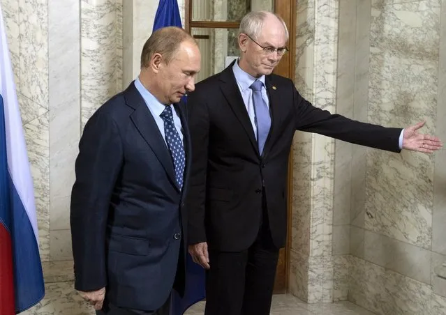 EU Council President Herman Van Rompuy (R) shows the way to Russia's President Vladimir Putin as they meet in Brussels, on December 20, 2012. Putin arrived yesterday in Brussels to take part in a working session of the 30th EU-Russia summit at EU headquarters. (Photo by Sergei Guneyev/AFP Photo/RIA-Novosti)