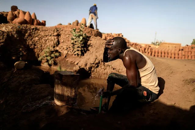 David Plantino, 35, a pottery maker from South Sudan, cools himself down with water from the Nile river, next to a workshop in an area known as the “Potters Village” in Alqamayir, Omdurman, Sudan, February 16, 2020. (Photo by Zohra Bensemra/Reuters)
