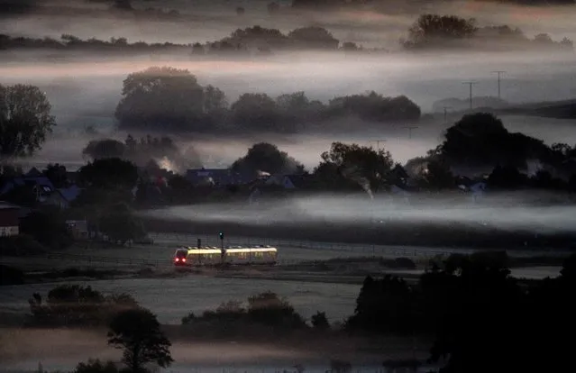 A regional train passes fog-covered fields in Wehrheim near Frankfurt, Germany, early Friday, October 7, 2022. (Photo by Michael Probst/AP Photo)
