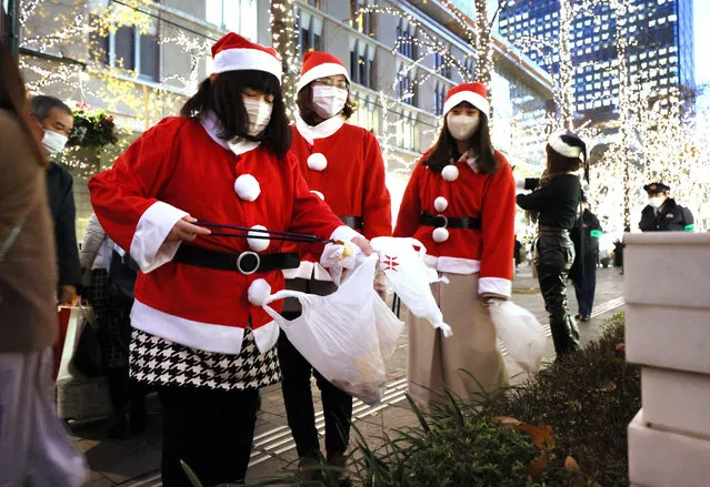Office workers in Santa costumes collect rubbish in Tokyo’s Marunouchi business district for the Christmas Santa clean-up parade in Tokyo, Japan on December 23, 2022. (Photo by Aflo Co Ltd/Alamy Live News)