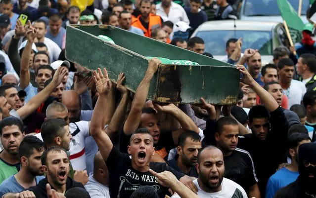 Mourners carry the body of 22-year-old Palestinian Ahmad Qali, who was shot by Israeli troops during clashes on Friday, during his funeral in the Palestinian refugee camp of Shuafat near Jerusalem October 10, 2015. (Photo by Ammar Awad/Reuters)