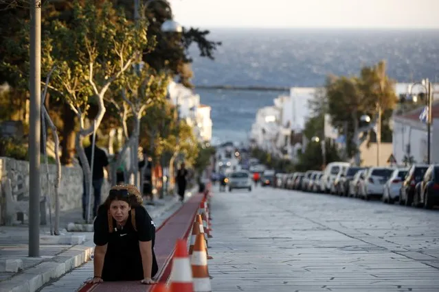 A pilgrim crawls from the port to the Holy Church of Panagia of Tinos, on the Aegean island of Tinos, Greece, on Thursday, August 13, 2020. For nearly 200 years, Greek Orthodox faithful have flocked to Tinos for the August 15 feast day of the Assumption of the Virgin Mary, the most revered religious holiday in the Orthodox calendar after Easter. But this year there was no procession, the ceremony – like so many lives across the globe – upended by the coronavirus pandemic. (Photo by Thanassis Stavrakis/AP Photo)