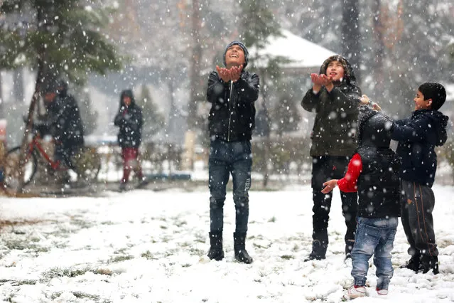 Boys play in a park during snowfall in Kabul on December 29, 2022. (Photo by AFP Photo/Stringer)