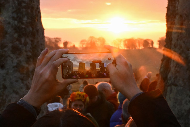 A person takes a picture as revellers attend spring equinox celebrations during sunrise at Stonehenge stone circle, near Amesbury, Britain, on March 20, 2025. (Photo by Jaimi Joy/Reuters)