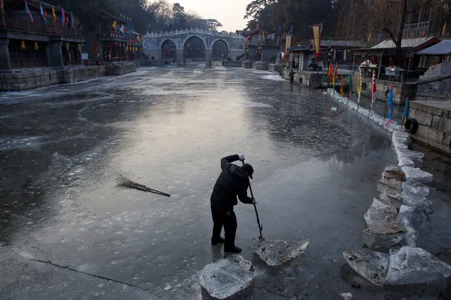 A worker removes ice in a canal in a park at the Old Summer Palace in Beijing, China December 27, 2017. (Photo by Thomas Peter/Reuters)