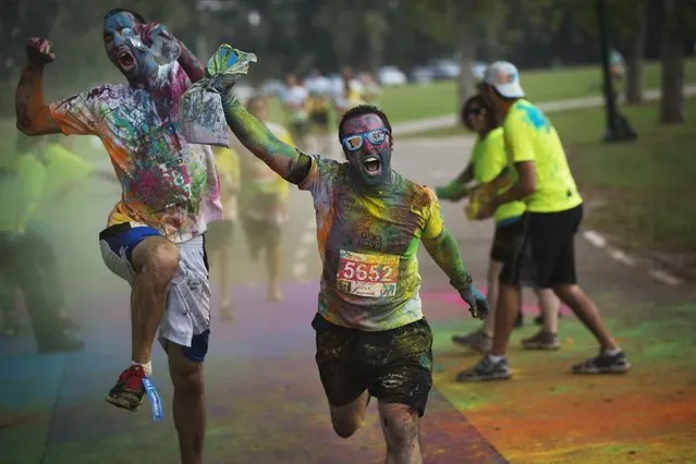 Participants in an amateur “Running in Color” event approach the finish line of a five kilometre (three mile) race in Tel Aviv, November 14, 2014. Inspired by the Hindu Holi festival, the race involved participants running along a course dotted with locations where coloured powders were thrown over the runners. The event was held to raise awareness about Post Traumatic Stress Disorder caused by conflict in the country. (Photo by Finbarr O'Reilly/Reuters)