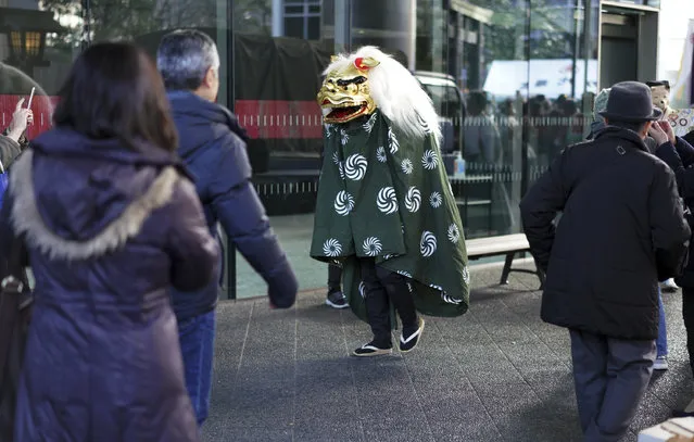 A lion dancer, known as Shishimai, walks prior to their ritual performance during First Konpira Festival at Kotohira-gu shrine in Tokyo Wednesday, January 10, 2018. People believe Shishimai lion dance, performed on New Year's Day season, brings good fortune and dispels evils. (Photo by Eugene Hoshiko/AP Photo)