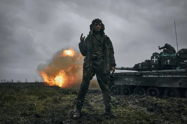 A Ukrainian soldier gestures as a captured Russian tank T-80 fires at the Russian position in Donetsk region, Ukraine, Tuesday, November 22, 2022. (Photo by LIBKOS/AP Photo)
