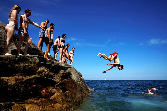 A young boy jumps off the Forty Foot rock into the sea during a heatwave, in Sandycove, Ireland, on July 13, 2025. (Photo by Clodagh Kilcoyne/Reuters)