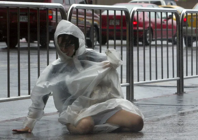 A pedestrian falls as a result of strong winds brought by typhoon Morakot in Taipei, August 2009. (Photo by Pichi Chuang/Reuters)