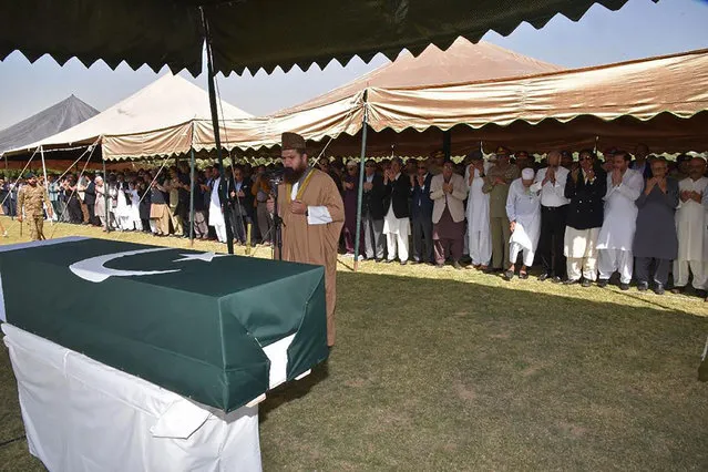 This handout photograph taken on February 7, 2023 and released by Pakistan's Inter-Services Public Relations (ISPR) shows military officials and others offering funeral prayers in front of the coffin of former military ruler Pervez Musharraf, in Karachi. Pakistan's divisive former military ruler Pervez Musharraf was buried on February 7 in a muted funeral that was never officially announced. (Photo by Pakistan's Inter-Services Public Relations (ISPR)/AFP Photo)
