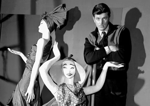 In this February 1, 1952 file photo, French fashion designer Hubert de Givenchy poses with mannequins in his shop in Paris. French couturier Hubert de Givenchy, a pioneer of ready-to-wear who designed Audrey Hepburn's little black dress in “Breakfast at Tiffany's”, has died at the age of 91. (Photo by AP Photo)