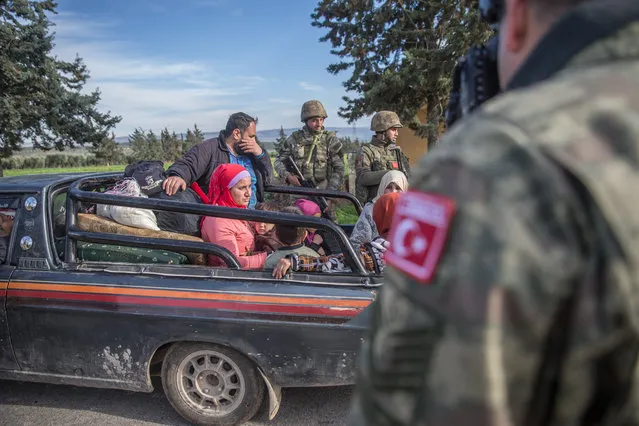 Syrian family encounter with Turkish soldiers as they patrol at the streets as search operations continue in Afrin town center after Turkish Armed Forces and Free Syrian Army (FSA) took complete control of northwestern Syria's Afrin within the 'Operation Olive Branch' on March 21, 2018. After the Turkish military and Free Syrian Army liberated the Afrin town center from YPG/PKK and Daesh terrorists on Sunday, fresh aerial footage showed that the civilians and buildings there remained unharmed. The Turkish troops and Free Syrian Army fighters took control of the Afrin town center on March 18, 2018 as part of Operation Olive Branch, which was launched on Jan. 20 to clear the area of YPG/PKK-Daesh terrorists. (Photo by Halil Fidan/Anadolu Agency/Getty Images)