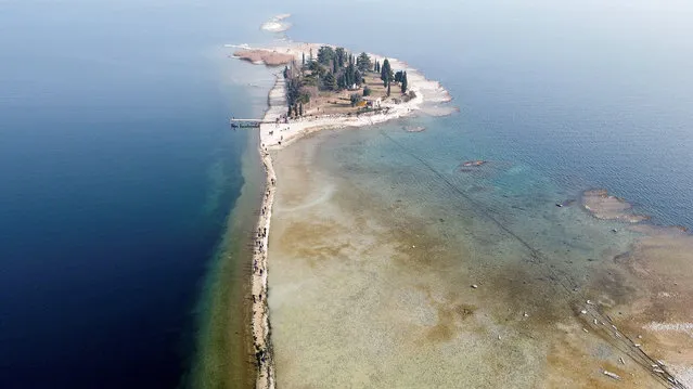 A drone image shows San Biagio island, affected by drought in Lake Garda, near Lido di Manerba, Italy on 21 February, 2023. (Photo by Alex Fraser/Reuters)