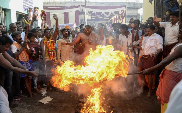 Indian Tamil Hindu devotees perform a ritual during the “Panguni Uthiram” festival in Jalandhar on March 30, 2018. The festival is observed in the Tamil month of Panguni and is celebrated to honour the Hindu God Murugan. Devotees make offerings through sacrificial feats they believe will keep them away from evil spirits. (Photo by Shammi Mehra/AFP Photo)