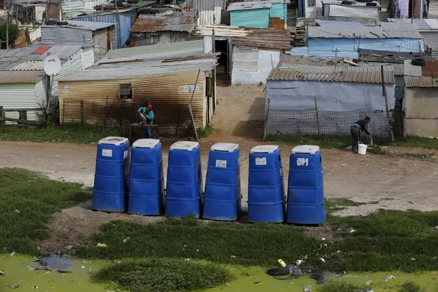 Temporary toilets stand in front of shacks in Khayelitsha township, Cape Town, South Africa, October 14, 2015. Twenty years after South Africa's first democratic elections, the slow pace of delivery of basic services remains a point of tension in some communities. (Photo by Mike Hutchings/Reuters)