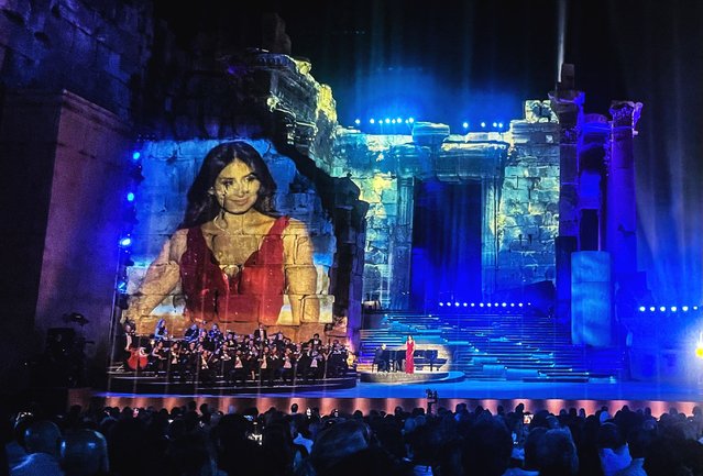An image of Lebanese singer Hiba Tawwaji is projected on the outer wall of the Roman ruins of the Temple of Bacchus, as she performs during the Baalbeck International Festival in the eponymous Lebanese city in the eastern Bekaa Valley, late on August 8, 2025. (Photo by Rita Hage/AFP Photo)