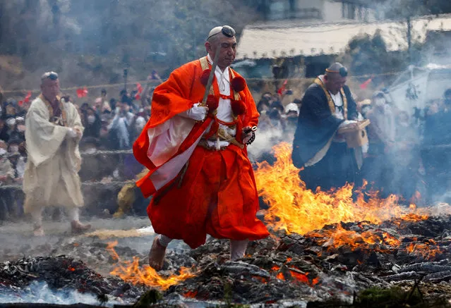 Buddhist monks walk over smouldering coals with barefoot at the fire-walking festival, called Hiwatari Matsuri in Japanese, at Mt.Takao in Tokyo, Japan, March 13, 2022. About 1,500 Japanese worshipers walk barefoot with Buddhist monks over coals at the annual festival praying for the safety of themselves, to overcome the coronavirus disease (COVID-19) pandemic and for peace in the world, Takao-san Yakuo-in Buddhist temple said. (Photo by Kim Kyung-Hoon/Reuters)