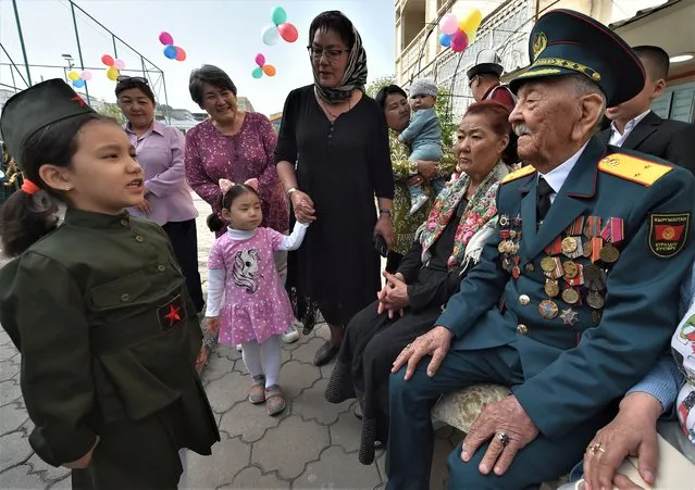 World War Two veteran Asek Urmambetov, 100, receives congratulations from Kyrgyz people during the Victory Day celebrations in Bishkek on May 8, 2023. Kyrgyzstan will celebrate the 78th anniversary of the 1945 victory over Nazi Germany on May 9. (Photo by Vyacheslav Oseledko/AFP Photo)