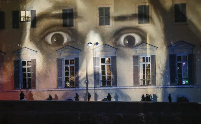 A light installation is seen on the facade on the banks of the Saone river to pay tribute to the victims of the Paris attacks in Lyon, France, December 8, 2015. (Photo by Robert Pratta/Reuters)