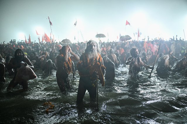 Sadhus, or Hindu holy men, take part in a mass bathing ritual in Sangam, the confluence of Ganges, Yamuna and mythical Saraswati rivers, during Shahi Snan, or “royal bath”, to mark the Maha Kumbh Mela festival in Prayagraj on January 14, 2025. Vast crowds of Hindu pilgrims in India bathed in sacred waters as the Kumbh Mela festival opened on January 13, with organisers expecting 400 million people – the world's largest gathering of humanity – to assemble over six weeks. (Photo by Idrees Mohammed/AFP Photo)