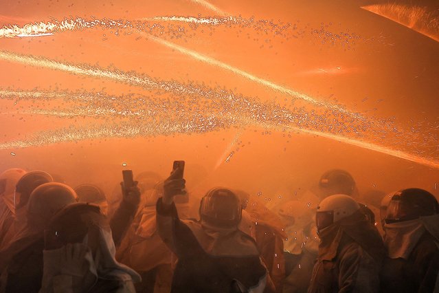 People wear protective outfits as firecrackers explode during the Yanshui Beehive Fireworks Festival as part of the Lantern Festival celebrations in Tainan, Taiwan, on February 11, 2025. (Photo by Ann Wang/Reuters)