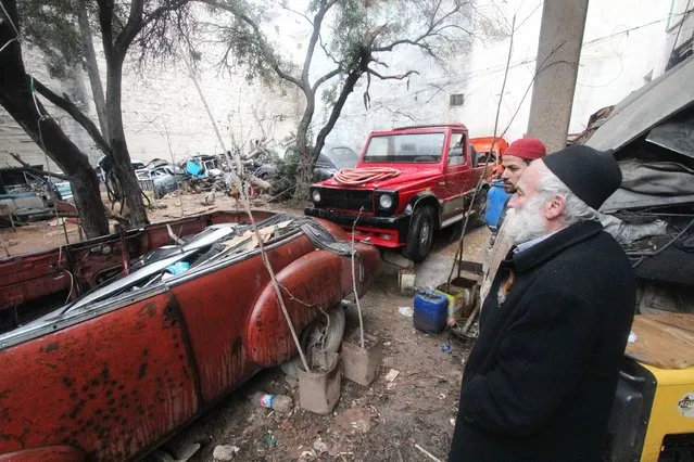 Mohamed Badr al-Din stands in front of one of his vintage cars, along a street where he keeps the cars, in the al-Shaar neighborhood of Aleppo January 31, 2015. (Photo by Abdalrhman Ismail/Reuters)