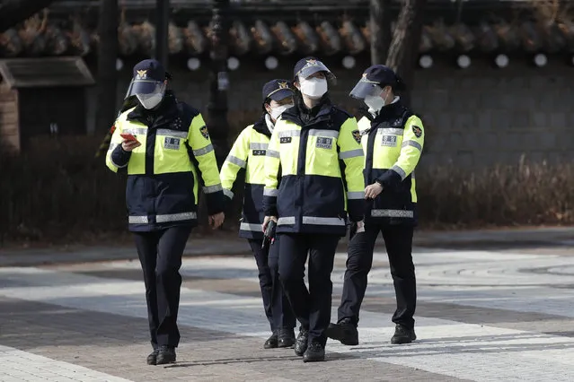 South Korean police officers wearing face masks as a precaution against the coronavirus, walk in Seoul, South Korea, Monday, January 25, 2021. (Photo by Lee Jin-man/AP Photo)