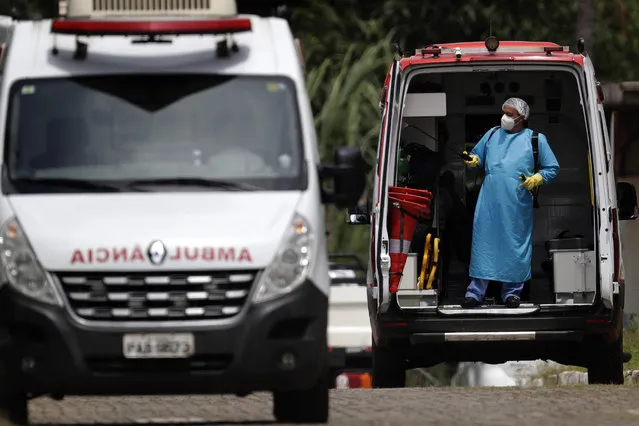 A healthcare worker disinfects an ambulance used to transport a patient suspected of having COVID-19, at the HRAN public hospital in Brasilia, Brazil, Tuesday, March 23, 2021. Hundreds of Brazilian economists, including former finance ministers and central bank presidents, urged the Brazilian government in an open letter published on Monday to speed up vaccination and adopt tougher restrictions to stop the rampant spread of the new coronavirus. (Photo by Eraldo Peres/AP Photo)