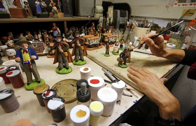 A worker paints a santon, the typical figurines from Provence, at the Marcel Carbonel's Santon factory in Marseille, November 28, 2016. (Photo by Jean-Paul Pelissier/Reuters)