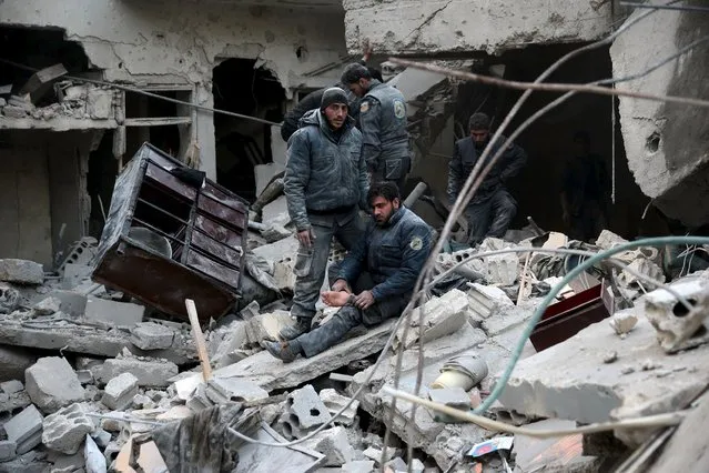 Civil defence members rest amidst rubble in a site hit by what activists said were airstrikes carried out by the Russian air force in the town of Douma, eastern Ghouta in Damascus, Syria January 10, 2016. (Photo by Bassam Khabieh/Reuters)